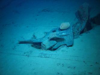 Stbd anchor embedded in steel plate from ship's side in debris field